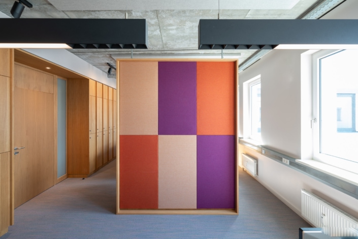Raumtrenner mit akustischer Wirkung im individuellen Farbkonzept, in Holz eingefasst und Sondergröße.